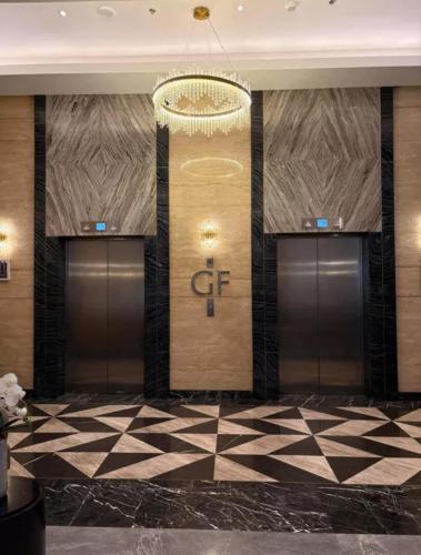 a row of elevator doors in a building with a chandelier at Aurora Escalades Residences in Manila