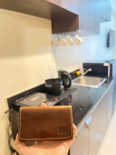 a person holding up a wallet in a kitchen at Aurora Escalades Residences in Manila