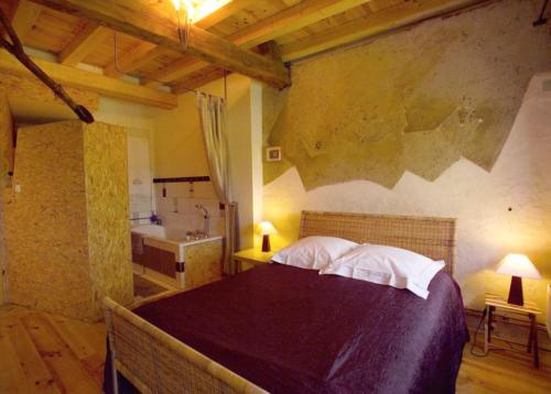 a bedroom with a large bed and a bathroom at Chambre d'hôtes du Moulin de Landonvillers in Courcelles-Chaussy