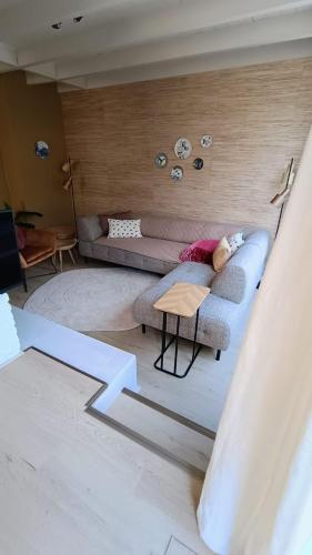 a living room with a couch and a table at Vakantiehuis Lycka in Noordwijkerhout