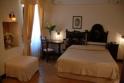 a bedroom with a bed and a table and a chair at Hotel Villa Palocla in Sciacca