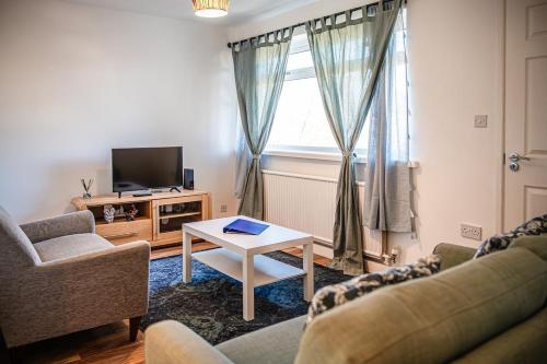 a living room with two couches and a tv at 2 Bedroom Apartment Denton, suitable for professionals needing a peaceful work environment in Manchester