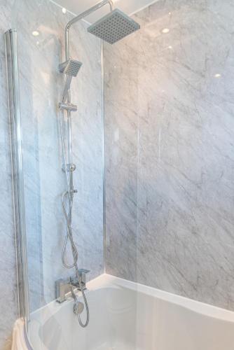 a shower with a glass door in a bathroom at 2 Bedroom Apartment Denton, suitable for professionals needing a peaceful work environment in Manchester