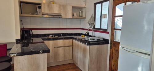 a kitchen with a sink and a stove in it at Hogar Doña Gloria in Iquique
