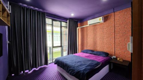 ein Schlafzimmer mit einem Bett und einer Ziegelwand in der Unterkunft Ber Ben House in Bang Su