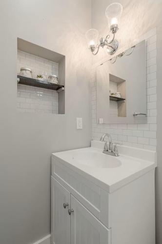 a white bathroom with a sink and a mirror at Riverside Hideaway - Brand New Deck! in Cincinnati