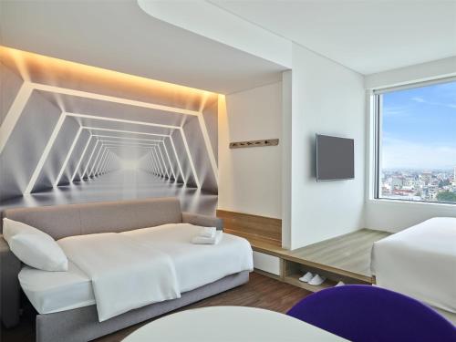 a bedroom with a white bed and a window at Tru by Hilton Bac Giang City Centre in Bắc Giang