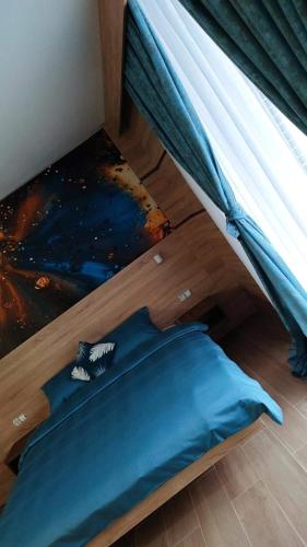 a bedroom with a bed with a blue comforter at Motel "KULA" in Cazin