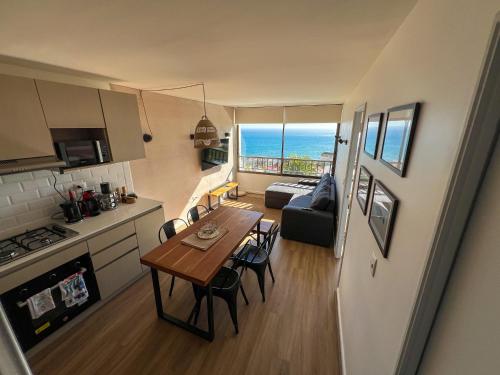 a kitchen and a living room with a table and chairs at Sunset Perfecto en Reñaca Host in Viña del Mar