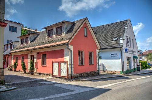 a red and white building on the side of a street at Penzion Novopacké Sklepy in Nová Paka