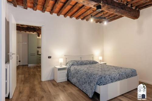 a white bedroom with a bed and two night stands at I due Ciueli in Pescia