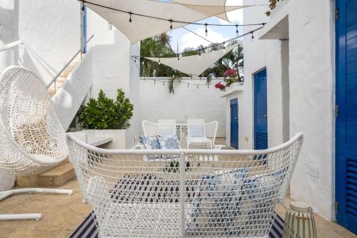 a balcony with white chairs and an umbrella at Ocean Park 1BD 1BA Pool Walk to beach -Santorini4 in San Juan