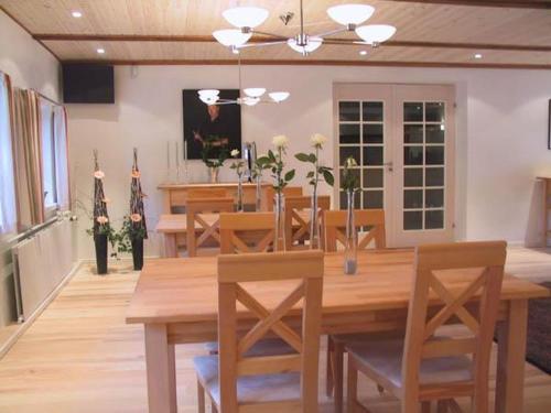 a dining room with a wooden table and chairs at Best Bed in Herning