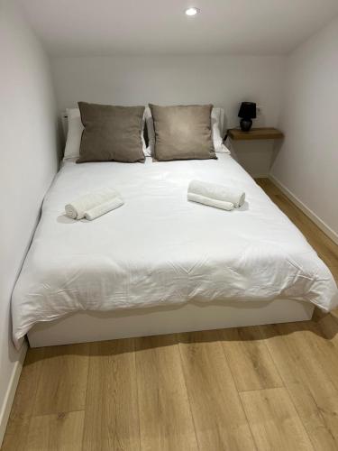 a large white bed with two towels on it at Charming Alpine Apartment with Sauna in Kobarid