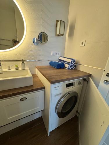 a bathroom with a washing machine and a sink at BalaLove Full Panoramic view in Szántód