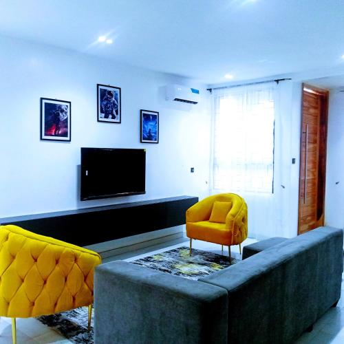 a living room with a couch and a television at Ifemide Estates - Luxury Homes in Akure