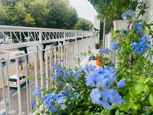 a white fence with blue flowers next to a street at Luxury Relax Apartment near Venice Station in Venice