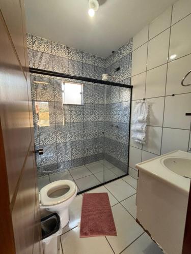 a bathroom with a shower with a toilet and a sink at Chácara a 2km do centro de São Thomé in São Thomé das Letras
