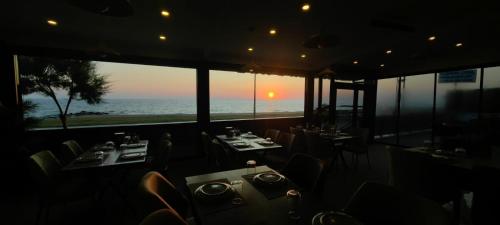 a restaurant with tables and chairs and a view of the ocean at istanbul Airport Kumsal Otel in Arnavutköy