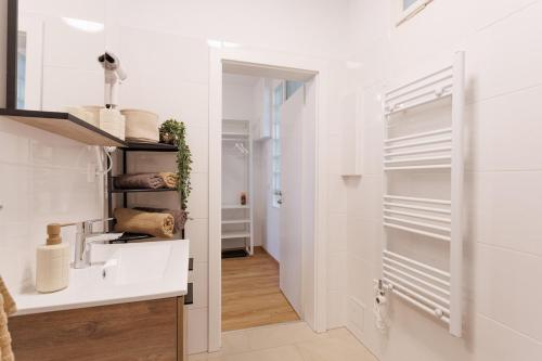 eine weiße Küche mit einem Waschbecken und einem Spiegel in der Unterkunft Central Renovated Apartment with AC & Free Parking in Wien