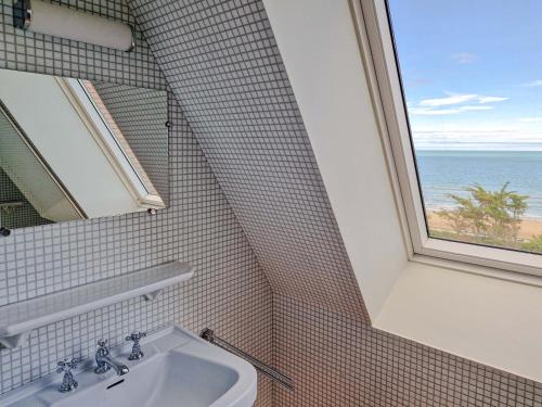 a bathroom with a sink and a window at La Sauvagère - Villa Art Deco face à Omaha Beach in Vierville-sur-Mer