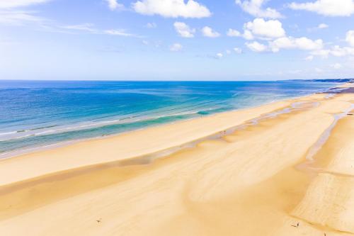 a sandy beach with the ocean in the background at La Sauvagère - Villa Art Deco face à Omaha Beach in Vierville-sur-Mer