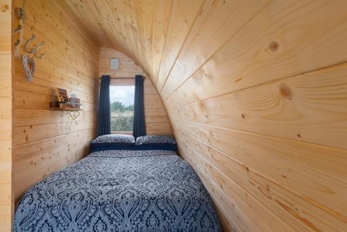 a small bedroom with a bed in a wooden wall at Duke End Retreat in Coleshill