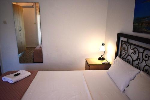a bedroom with a large bed and a mirror at Gianna Seaside in Koutsounari