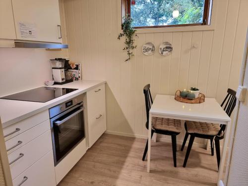 Central apartment في ترومسو: مطبخ صغير مع طاولة وطاولة وكراسي