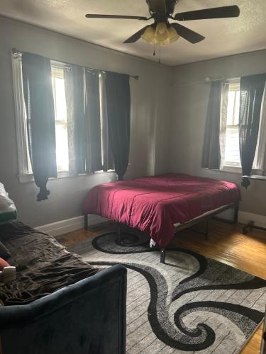 a bedroom with a red bed and a ceiling fan at Historic Retreat in Detroit