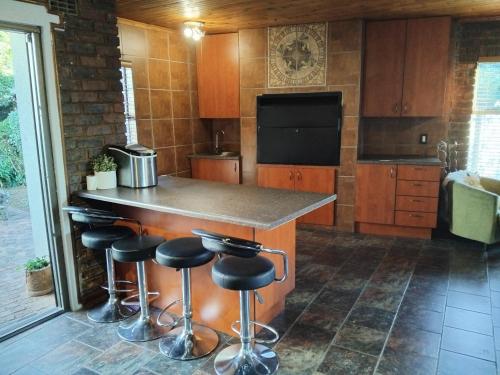 a kitchen with a counter and bar stools at Heather Guest House in Alberton
