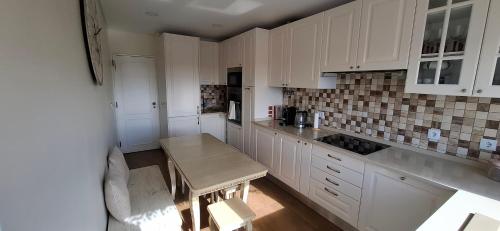 a kitchen with white cabinets and a table in it at Thouse Fontainhas in Cascais