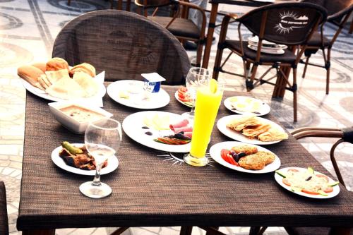 a table with plates of food and drinks on it at Nefri Pyramids Hotel in Cairo