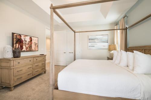 a bedroom with a white bed and a wooden dresser at Cozy Home With Private Pool, Air Hockey Table Near Disney With Waterpark & Resort Access At Encore Resort - 7702Gr in Kissimmee