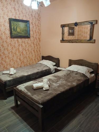 a bedroom with two beds and a painting on the wall at Etno kuća Biblioteka in Smederevo