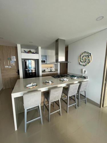 a kitchen with a table with chairs and a counter top at Reserva Del Mar Apartamentos in Gaira