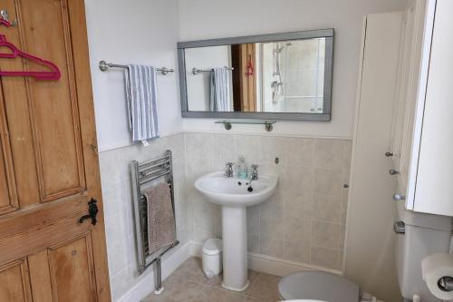 a bathroom with a sink and a mirror at Cosy 3 Bed Home, Holywell Green in Greetland