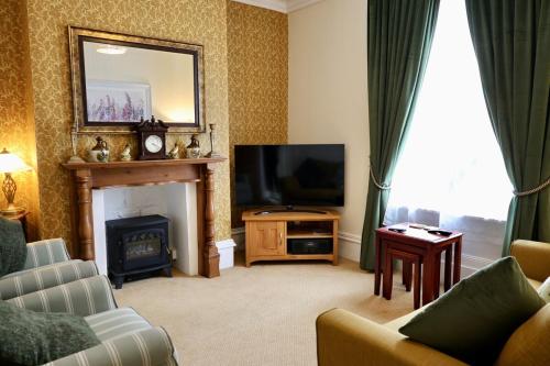 a living room with a fireplace and a television at Cosy 3 Bed Home, Holywell Green in Greetland