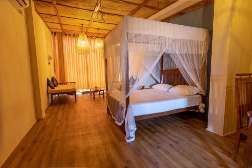 a bedroom with a bed with a canopy at Land of Joy in Ahangama