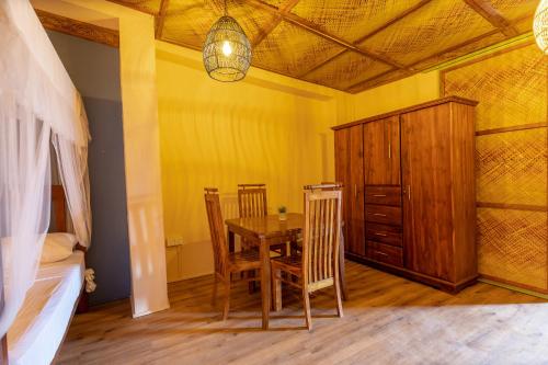 a dining room with a table and chairs and a bedroom at Land of Joy in Ahangama