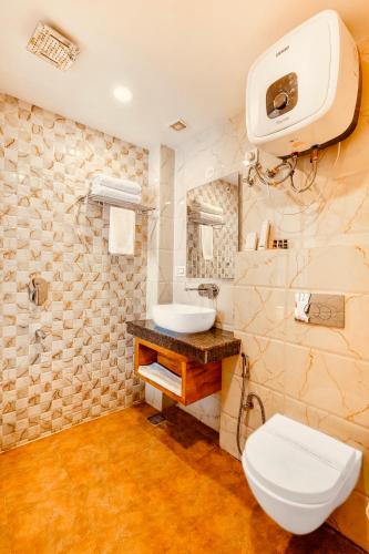 a bathroom with a white toilet and a sink at Hotel Classic Hills Bhagsunag Luxury Stay #Best Hotel in Mcleodganj #Mountain View Balcony Rooms #Spacious Parking #Prime Location in Dharamshala #Near Bhagsunag Waterfall #Top Selling Property in Mcleodganj in Dharmsala