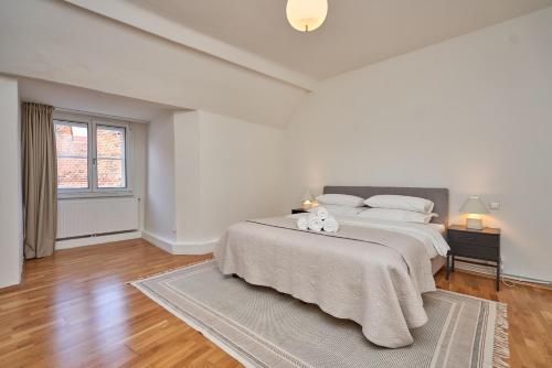 a white bedroom with a large bed with white pillows at Graz 1464, Old City Center Apartments in Graz