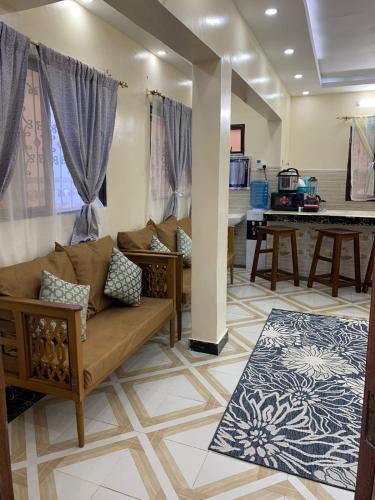 a living room with a couch and a piano at Fatnaish Riyadha Apartment in Lamu