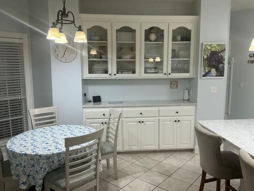 a kitchen with white cabinets and a table and chairs at Spacious King Suite Home With Serene Patio in Hattiesburg