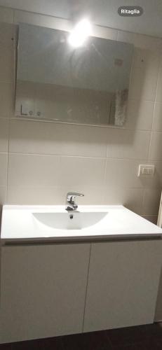 a white sink in a bathroom with a mirror at A casa di A in Milan