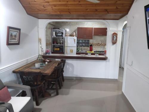 a kitchen with a wooden table and a refrigerator at Casa Familiar Vacacional Flandes in Flandes
