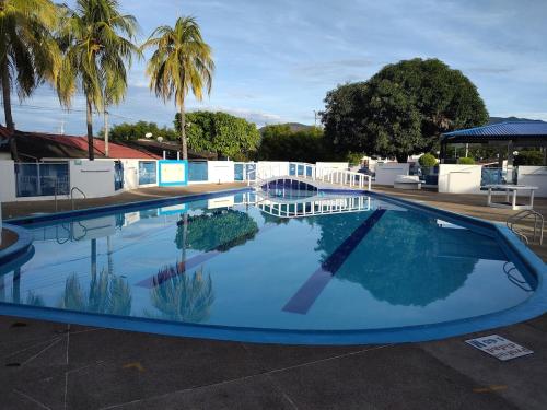 a large swimming pool with blue water and palm trees at Casa Familiar Vacacional Flandes in Flandes