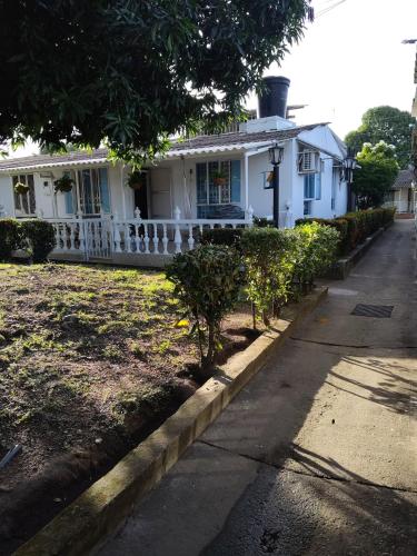 a white house with trees in front of it at Casa Familiar Vacacional Flandes in Flandes