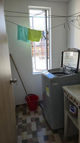 a kitchen with a trash can and a window at Apartasuite en Cartago in Cartago
