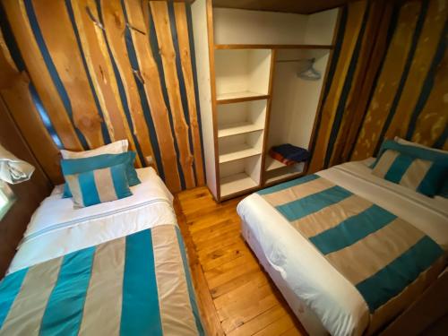 a small room with two beds and a closet at Exquisita Cabaña familiar a minutos del Lago Caburgua y Pucón in Caburgua